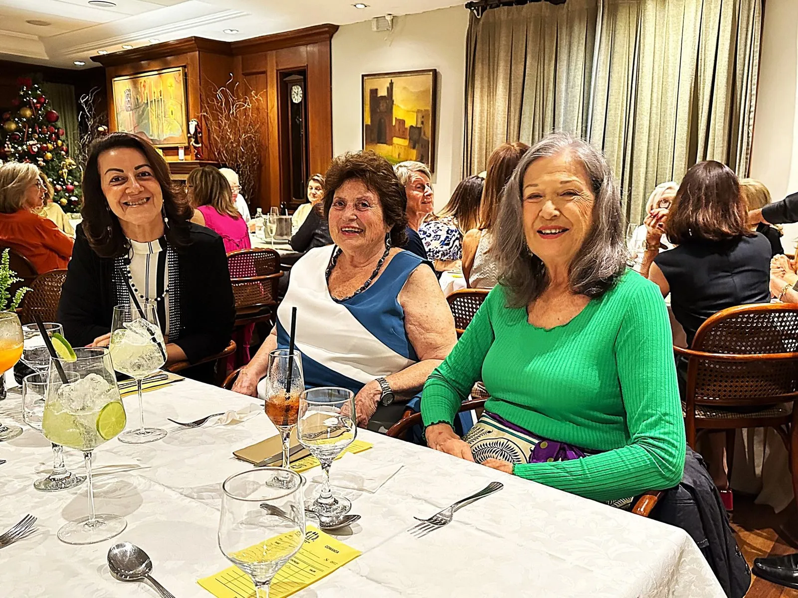 Alunas sorrindo à mesa num jantar de confraternização da CICLOS+
