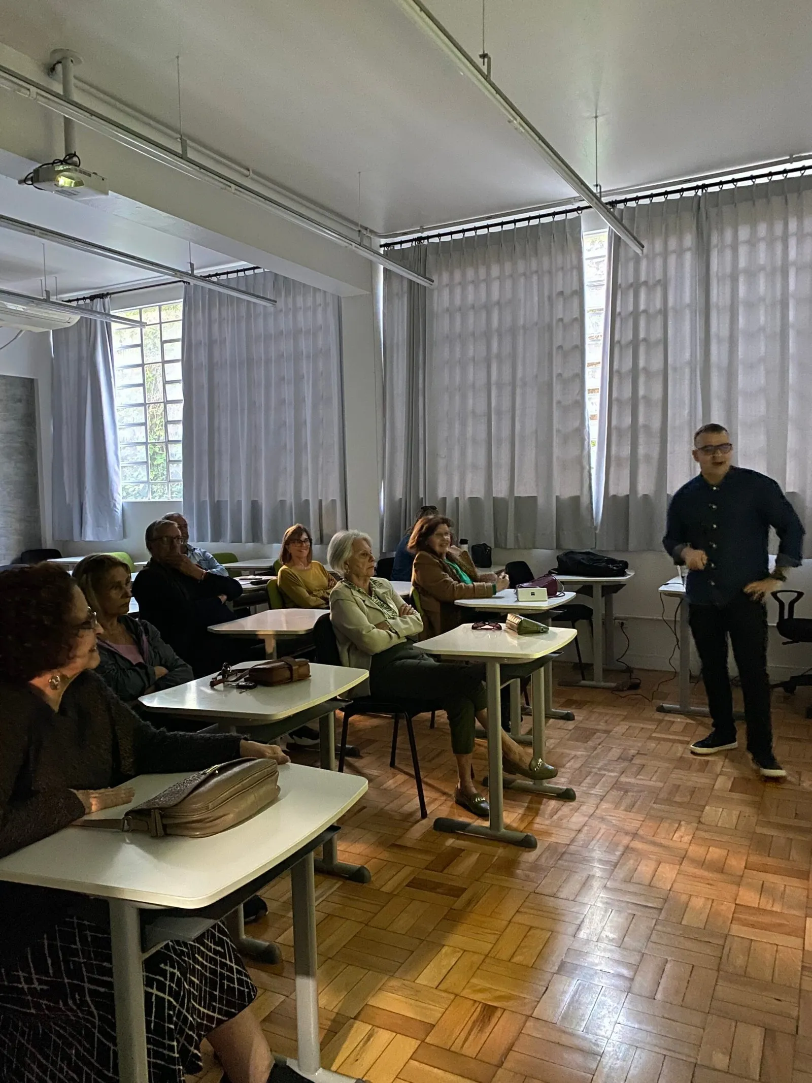 Professor conduz uma aula da CICLOS+ para uma sala cheia de alunos atentos