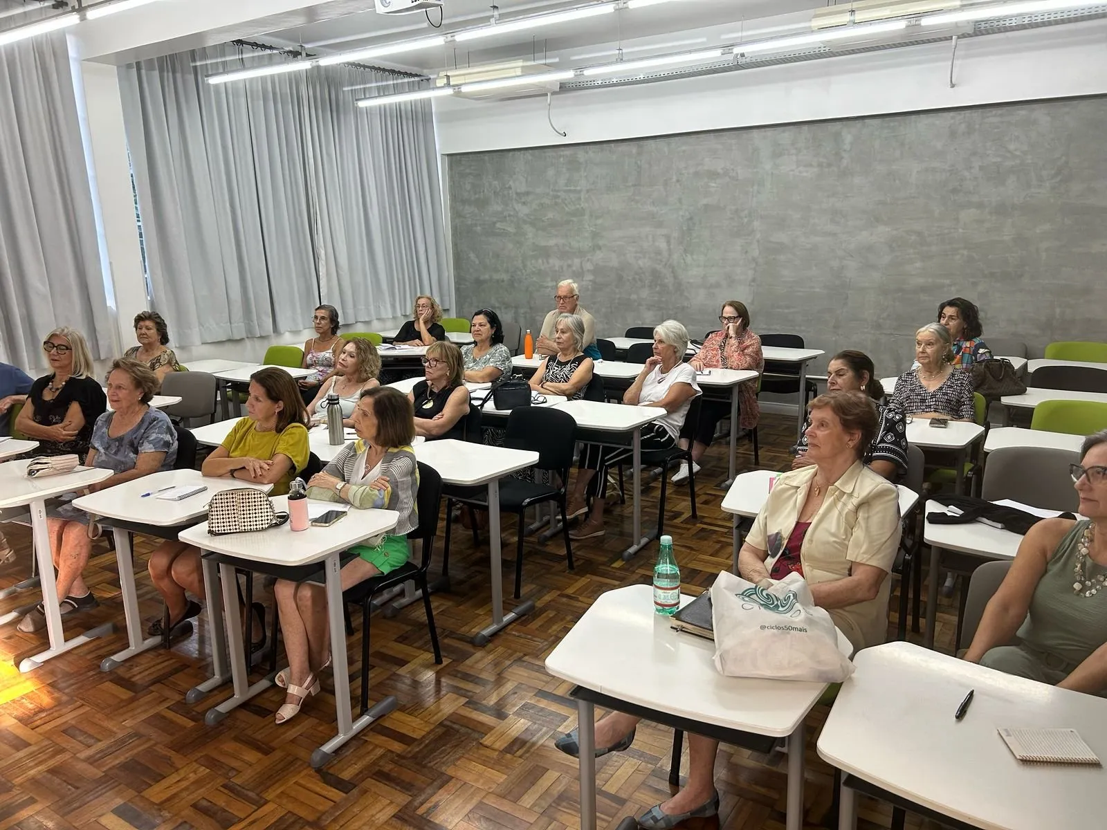 Sala de aula cheia, com alunas e alunos sentados em carteiras