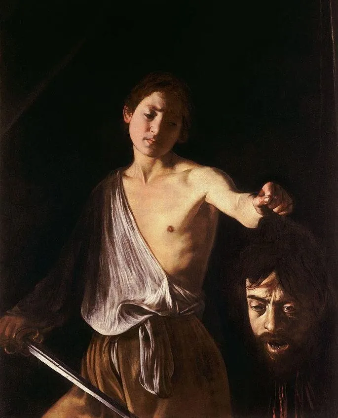 Pintura de Caravaggio: o jovem Davi, de expressão melancólica, segura a cabeça de Golias