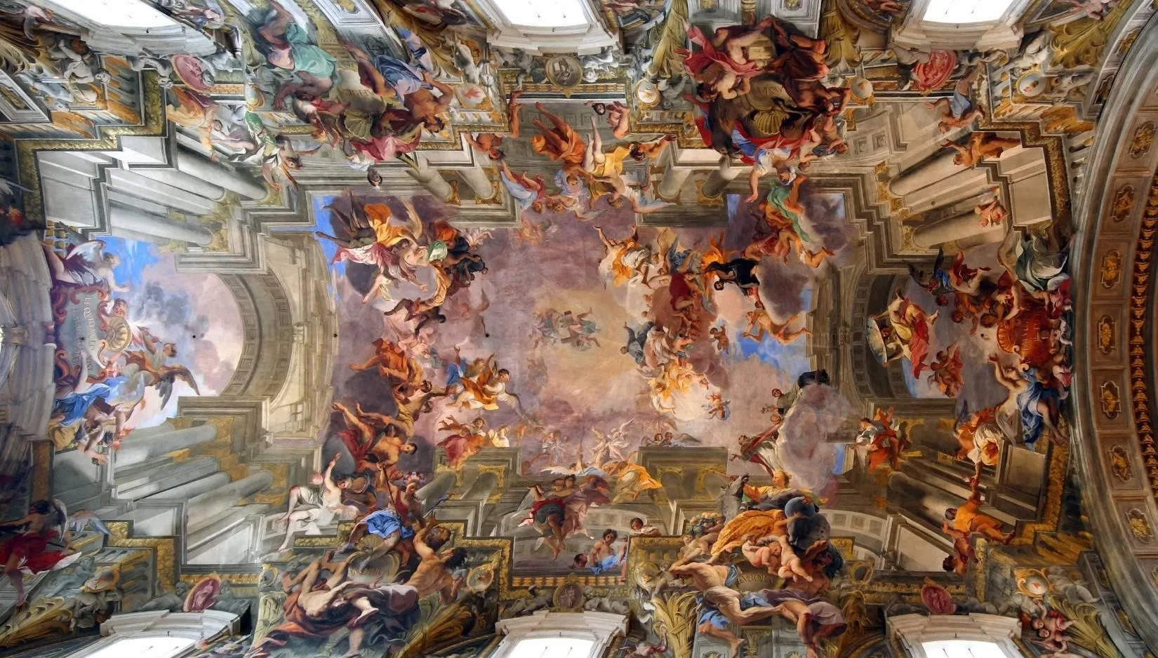 Teto pintado da Igreja de Santo Inácio, em Roma: céus abertos, nuvens e dezenas de figuras em perspectiva vertiginosa